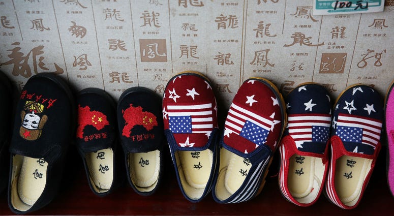 In this July 13, 2018, photo, Chinese-made childrens shoes carrying a Chinese map and U.S. flags are on display for a sale at a shop in Beijing. In this July 13, 2018, photo, Chinese-made childrens shoes carrying a Chinese map and U.S. flags are on display for a sale at a shop in Beijing.