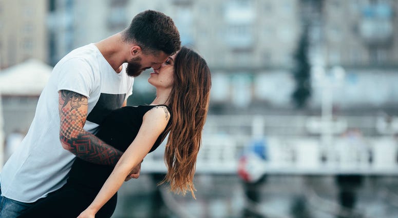 Couple kissing against the backdrop of the city Couple kissing against the backdrop of the city
