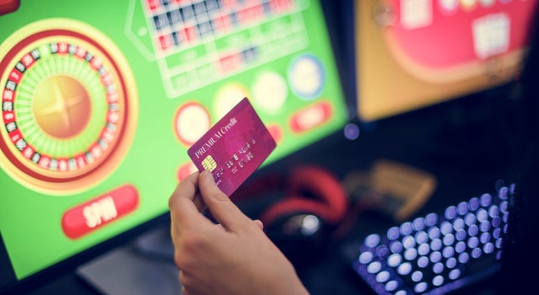 Hand holding credit card playing online gambling Online Gambling