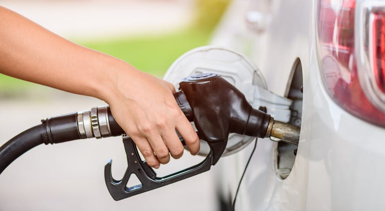 Woman pumping gasoline fuel in car at gas station. Woman pumping gasoline fuel in car at gas station.