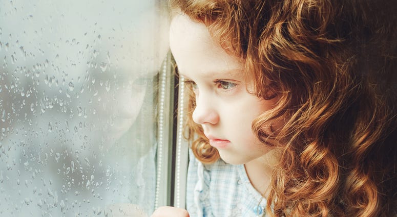 Sad child looking out the window. Sad Child