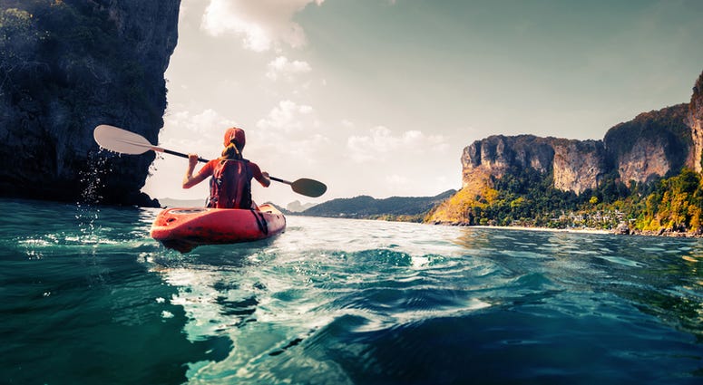 Lady paddling the kayak in the calm tropical bay Kayak