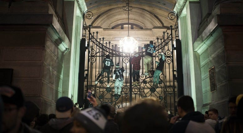 Philadelphia Eagles fans climb a gate outside City Hall as celebrations ensue along Broad Street in Philadelphia following a Super Bowl win against the New England Patriots, Feb. 5, 2018. Eagles fans