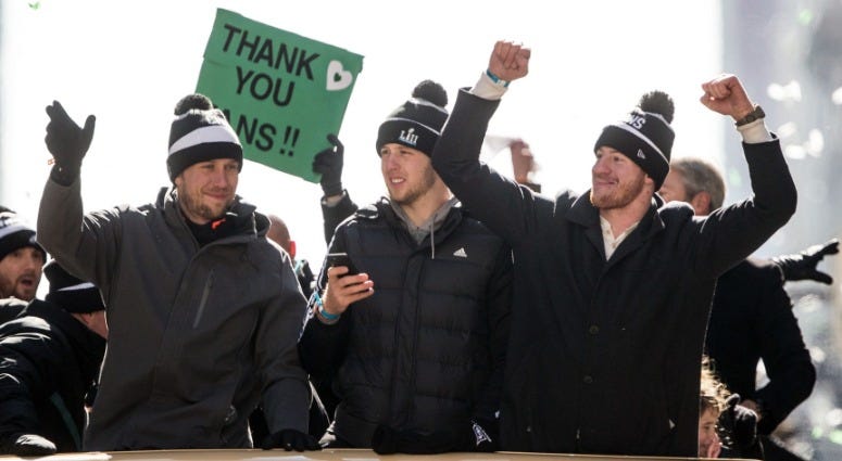 Philadelphia Eagles quarterback Nick Foles (left), quarterback Nate Sudfeld (middle) and quarterback Carson Wentz (right) ride atop a bus on the Super Bowl LII parade route in Philadelphia, Feb. 8, 2018. Eagles Super Bowl parade