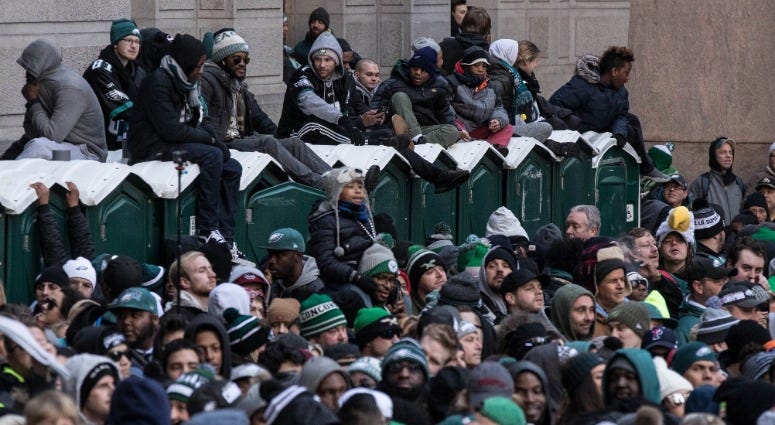 Fans sit on top of portable toilets to gain a better view of the Super Bowl LII Championship parade at City Hall, Feb. 8, 2018. Eagles Super Bowl parade