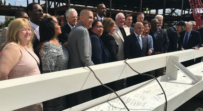 Officials gathered behind final steel girder before it was raised.