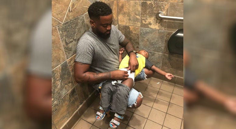 Donte Palmer changing his 1-year-old son.
