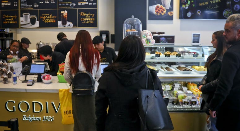 Customers wait in line for service at Godiva's new cafe in New York, Tuesday April 16, 2019. Customers wait in line for service at Godiva's new cafe in New York, Tuesday April 16, 2019.