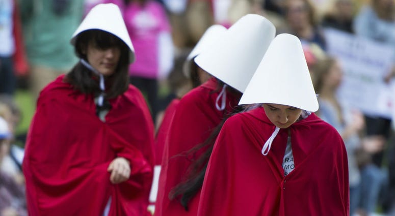 Oct 16, 2017; Greenville, SC, USA; Protestors dressed as characters from \"The Handmaids Tale\" attend a protest in Falls Park as President Donald Trump visits Greenville. Trump Visit Greenville