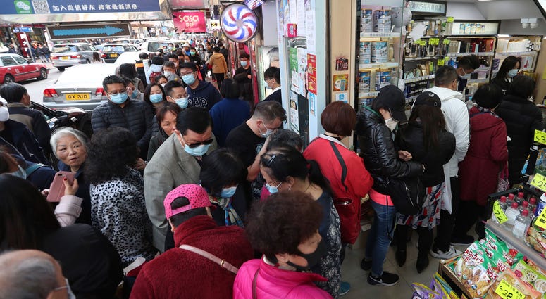 People queue for free face masks outside a cosmetics shop at Tsuen Wan in Hong Kong on January 28, 2020. Coronavirus Hong Kong