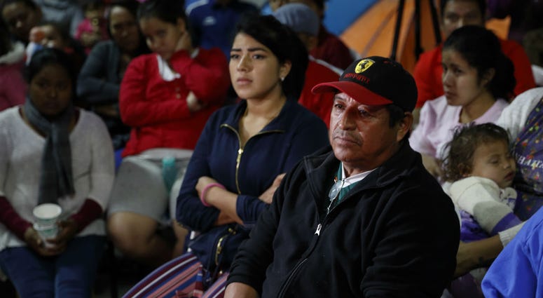 Migrants mainly from Mexico and Central America look on as U.S. President Donald Trump gives a prime-time address about border security on television, Tuesday, Jan. 8, 2019, watching from a border migrant shelter in Tijuana, Mexico. Migrants mainly from Mexico and Central America look on as U.S. President Donald Trump gives a prime-time address about border security on television, Tuesday, Jan. 8, 2019, watching from a border migrant shelter in Tijuana, Mexico.