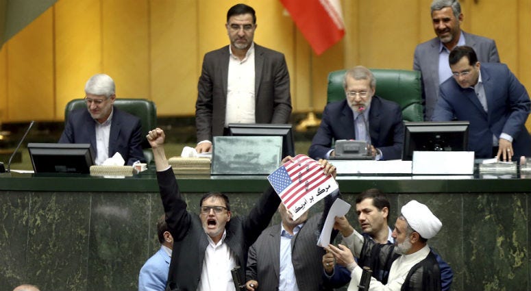 Iranian lawmakers burn two pieces of papers representing the U.S. flag and the nuclear deal as they chant slogans against the U.S. at the parliament in Tehran, Iran, Wednesday, May 9, 2018. Iranian lawmakers burn two pieces of papers representing the U.S. flag and the nuclear deal as they chant slogans against the U.S. at the parliament in Tehran, Iran, Wednesday, May 9, 2018.