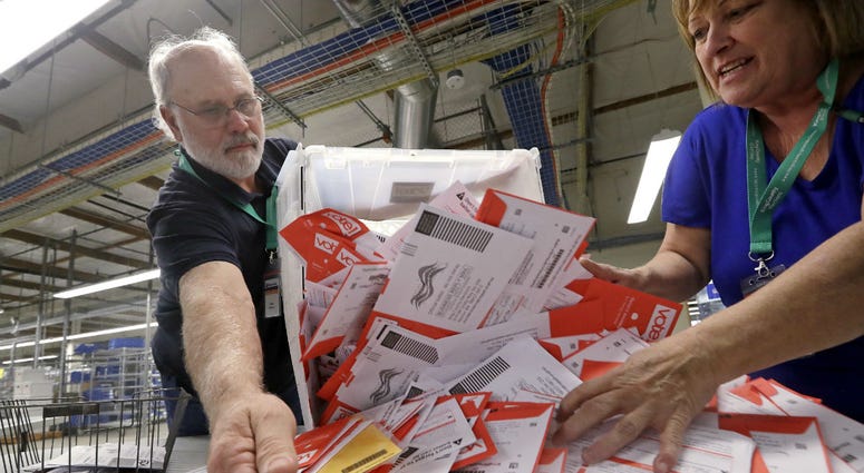 Election workers Mark Bezanson, left, and Julie Olson dump ballots collected earlier in the day from drop boxes onto a table for sorting at the King County Elections office, Monday, Nov. 5, 2018, in Renton, Wash. Election workers Mark Bezanson, left, and Julie Olson dump ballots collected earlier in the day from drop boxes onto a table for sorting at the King County Elections office, Monday, Nov. 5, 2018, in Renton, Wash.