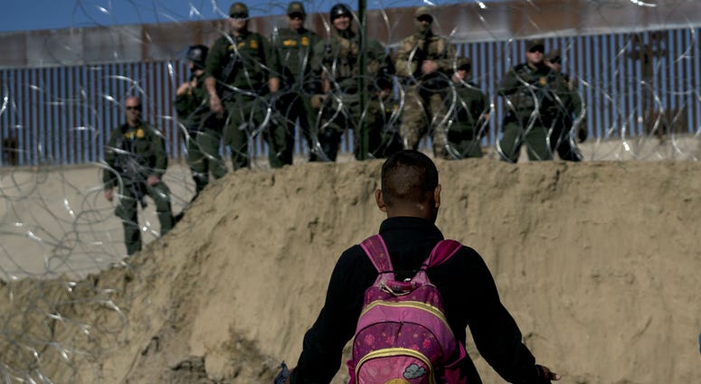 A Honduran migrant converses with U.S border agents on the other side of razor wire after they fired tear gas at migrants pressuring to cross into the U.S. from Tijuana, Mexico, Sunday, Nov. 25, 2018. A Honduran migrant converses with U.S border agents on the other side of razor wire after they fired tear gas at migrants pressuring to cross into the U.S. from Tijuana, Mexico, Sunday, Nov. 25, 2018.