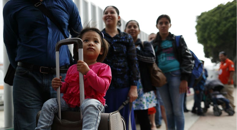 Calet Garcia, center, of Honduras, cries after he realizes he will be able to apply for asylum in the U.S. with his friend Daisy Avelar, second from left, of El Salvador, Thursday, July 26, 2018, near the San Ysidro port of entry in Tijuana, Mexico. Calet Garcia, center, of Honduras, cries after he realizes he will be able to apply for asylum in the U.S. with his friend Daisy Avelar, second from left, of El Salvador, Thursday, July 26, 2018, near the San Ysidro port of entry in Tijuana, Mexico.
