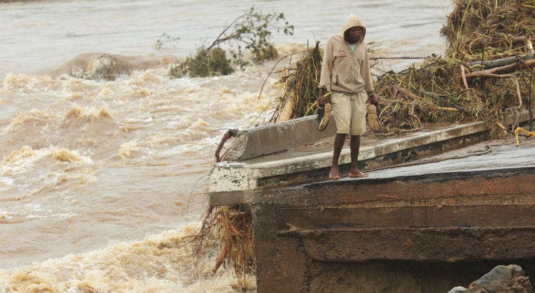 A man stands on the edge of a collapsed bridge in Chimanimani, about 600 kilometers southeast of Harare, Zimbabwe, Monday, March 18, 2019. A man stands on the edge of a collapsed bridge in Chimanimani, about 600 kilometers southeast of Harare, Zimbabwe, Monday, March 18, 2019.