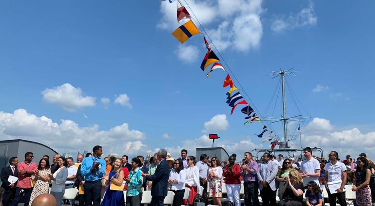 40 new Americans say the Oath of Allegiance at a Fourth of July naturalization ceremony aboard the Battleship New Jersey.