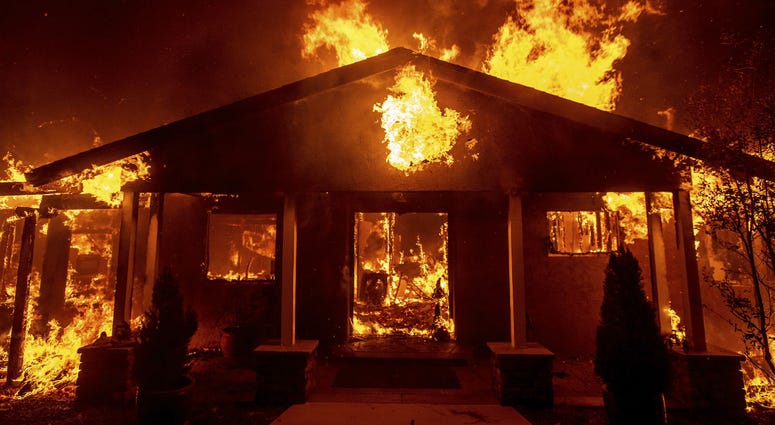 In this Thursday, Nov. 8, 2018 file photo, a home burns as the Camp Fire rages through Paradise, Calif. In this Thursday, Nov. 8, 2018 file photo, a home burns as the Camp Fire rages through Paradise, Calif.