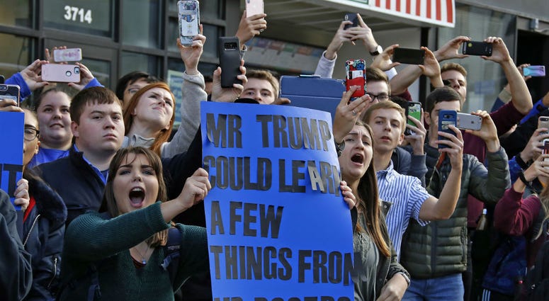 University of Pittsburgh sophomore Lynne Jaworski, from Homer City, Pa., holds a sign and yells as President Donald Trump's motorcade arrives at the University of Pittsburgh's Presbyterian Hospital. University of Pittsburgh sophomore Lynne Jaworski, from Homer City, Pa., holds a sign and yells as President Donald Trump's motorcade arrives at the University of Pittsburgh's Presbyterian Hospital.