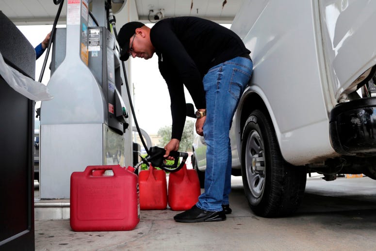 Arian Britto fills containers with gasoline at BJ's Wholesale Club in preparation for Hurricane Dorian, Thursday, Aug. 29, 2019, in Hialeah, Fla. Hurricane Dorian is heading toward Florida for a possible direct hit on the state over Labor Day. Hurricane Dorian preparations