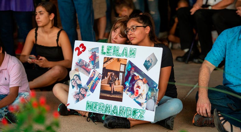 Celeste Lujan, left, and Yasmin Natera hold a sign in honor of Leilah Hernandez during a vigil for victims of the shooting spree the day before, Sunday, Sept. 1, 2019, at the University of Texas of the Permian Basin quad, in Odessa, Texas. Vigil for Odessa, Texas shooting