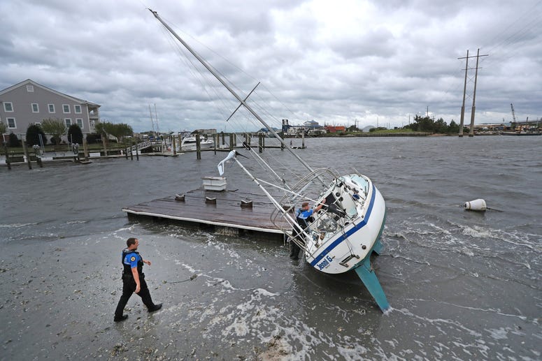Beaufort Police Officer Curtis Resor, left, and Sgt. Micheal Stepehens check a sailboat for occupants in Beaufort, N.C. after Hurricane Dorian passed the North Carolina coast on Friday, Sept. 6, 2019. Hurricane Dorian passed the North Carolina