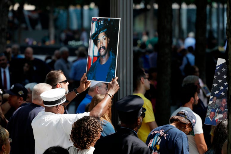 A photograph of fallen firefighter Leon Smith, Jr. is held up during a ceremony marking the 18th anniversary of the attacks of Sept. 11, 2001 at the National September 11 Memorial, Wednesday, Sept. 11, 2019 in New York. Anniversary of 9/11