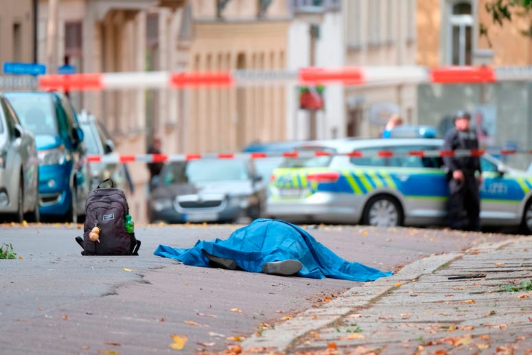 A body lies on a road in Halle, Germany, Wednesday, Oct. 9, 2019 after a shooting incident. A gunman fired several shots on Wednesday in German city of Halle and at least two got killed, according to local media FOCUS online. A body lies on a road in Halle, Germany.