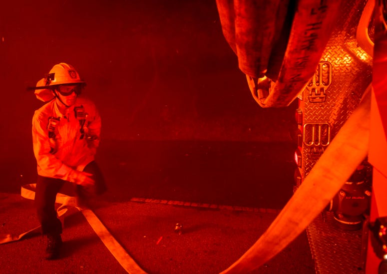 Firefighters try to save a home on Tigertail Road from the Getty Fire, Monday, Oct. 28, 2019, in Los Angeles, Calif. California wildfires