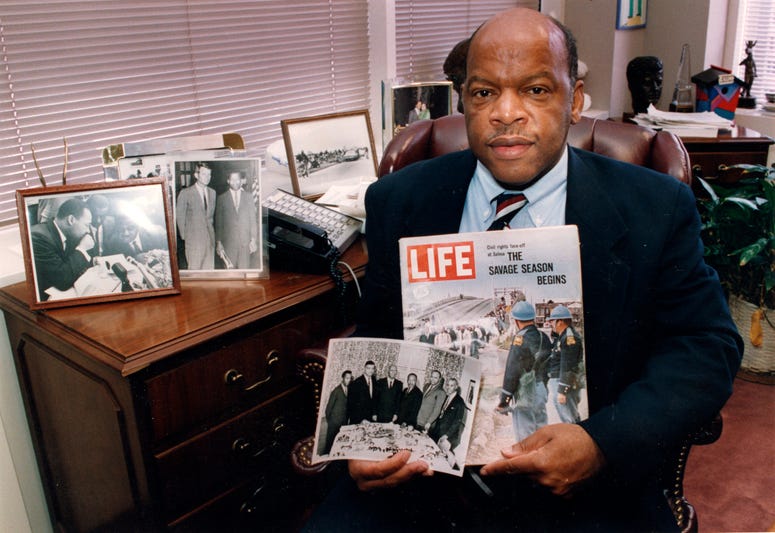 Congressman John Lewis poses in his Atlanta office with two of his favorite items from his collection of memorabilia from his younger days as a civil rights activist in the 1960s. Congressman John Lewis poses in his Atlanta office with two of his favorite items from his collection of memorabilia from his younger days as a civil rights activist in the 1960s.