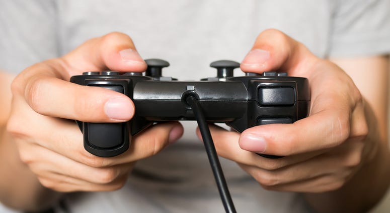 A young man holding game controller playing video games. Video Games