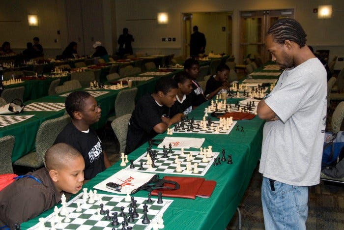 Mikyeil El-Mekki playing chess with his students. Mikyeil El-Mekki playing chess with his students.