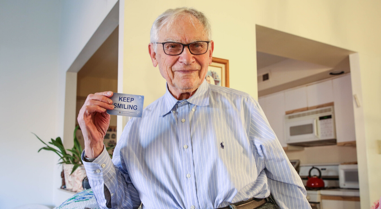 Ernie Gross, a Holocaust survivor, keeps a blue card in his pocket that reads, "KEEP SMILING." Ernie Gross