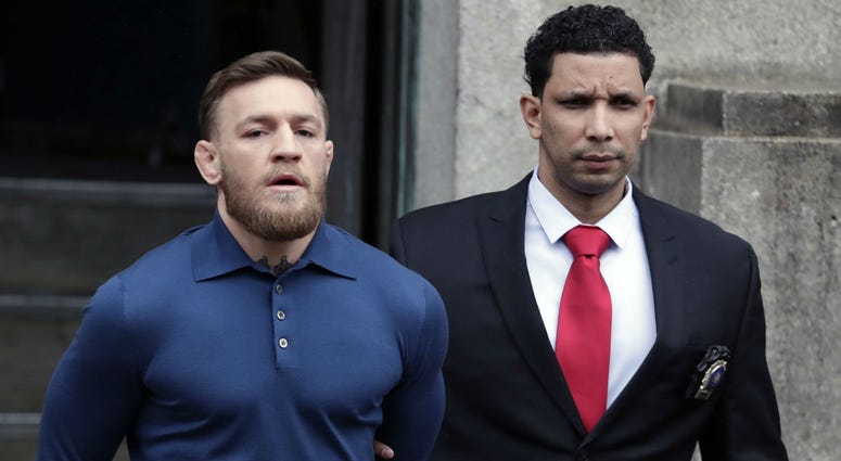 Ultimate fighting star Conor McGregor, left, is led by an official to an unmarked vehicle while leaving the 78th Precinct of the New York Police Department, Friday, April 6, 2018. Ultimate fighting star Conor McGregor, left, is led by an official to an unmarked vehicle while leaving the 78th Precinct of the New York Police Department, Friday, April 6, 2018.