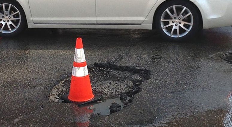 A driver negotiates past a formidable pothole on Fifth Street, north of Market, in center city Philadelphia. Pothole