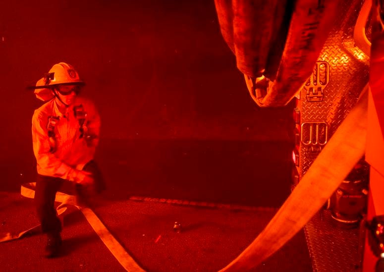Firefighters try to save a home on Tigertail Road from the Getty Fire, Monday, Oct. 28, 2019, in Los Angeles, Calif. California wildfires