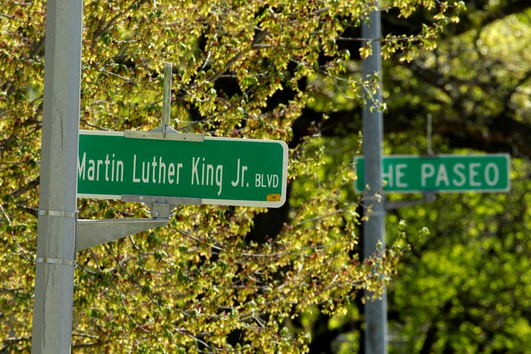 In this April, 20, 2019, file photo, a newly changed sign for Dr. Martin Luther King Jr. Boulevard stands in contrast to a yet-to-be changed sign for The Paseo, in Kansas City, Mo. King Boulevard debate