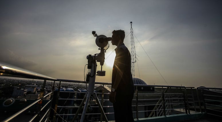 A man looks through a telescope to determine the sighting of the new moon to mark the start of the fasting month of Ramadan. A man looks through a telescope to determine the sighting of the new moon to mark the start of the fasting month of Ramadan.