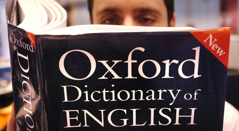 A man reading a copy of the Oxford Dictionary of English A man reading a copy of the Oxford Dictionary of English