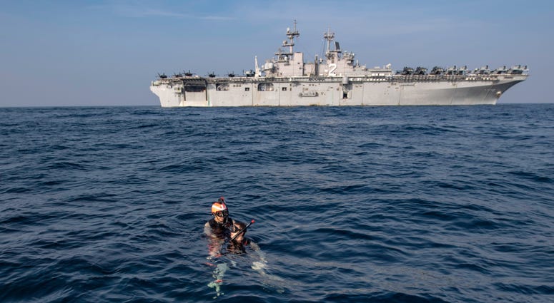 Interior Communications Electrician 2nd Class Nathan Miles, left, and Intelligence Specialist 2nd Class Emmitt Burke conduct search and rescue training during a man overboard drill while on a deployment, Jan. 15, 2019. A search and rescue training during a man overboard drill
