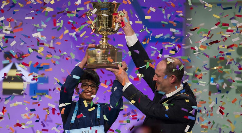 Karthik Nemmani, 14, from McKinney, Texas, is presented with the Scripps National Spelling Bee trophy by Adam Symson, president and CEO, E.W. Scripps Company, after he won the bee, in Oxon Hill, Md., Thursday, May 31, 2018. Karthik Nemmani, 14, from McKinney, Texas, is presented with the Scripps National Spelling Bee trophy