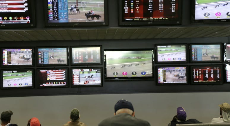 In this May 14, 2018, file photo, men watch horse racing on an array of screens at Monmouth Park Racetrack in Oceanport, N.J. In this May 14, 2018, file photo, men watch horse racing on an array of screens at Monmouth Park Racetrack in Oceanport, N.J.
