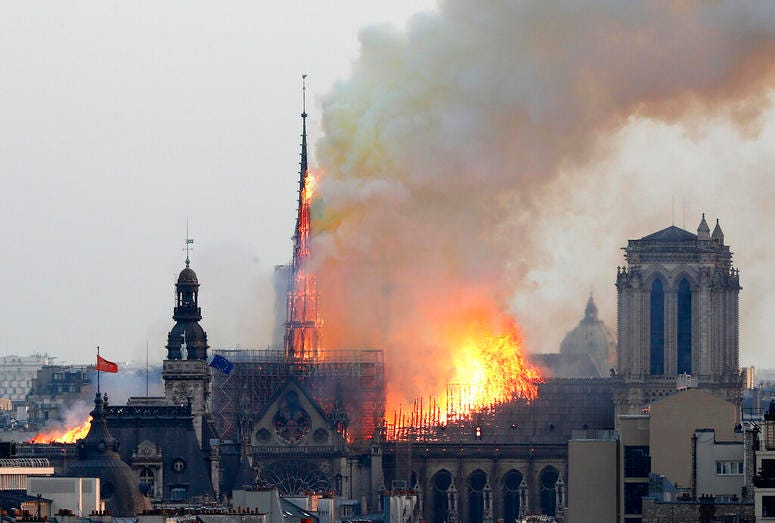 Flames rise from Notre Dame cathedral as it burns in Paris, April 15, 2019. Massive plumes of yellow brown smoke is filling the air above Notre Dame Cathedral and ash is falling on tourists and others around the island that marks the center of Paris. Notre Dame Cathedral fire