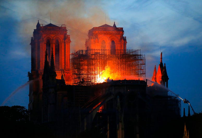 Firefighters tackle the blaze as flames and smoke rise from Notre Dame cathedral as it burns in Paris, Monday, April 15, 2019. Notre Dame Cathedral