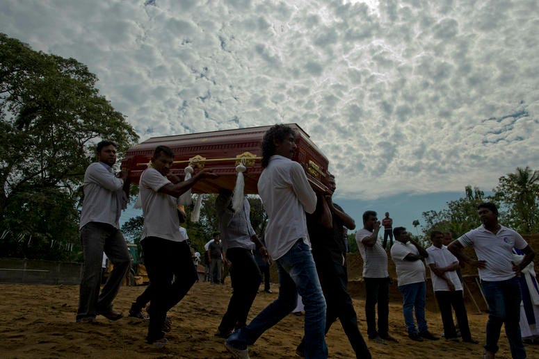 Relatives carry a coffin for burial during a mass burial for Easter Sunday bomb blast victims in Negombo, Sri Lanka, Wednesday, April 24, 2019. A mass burial for victims in Sri Lanka.