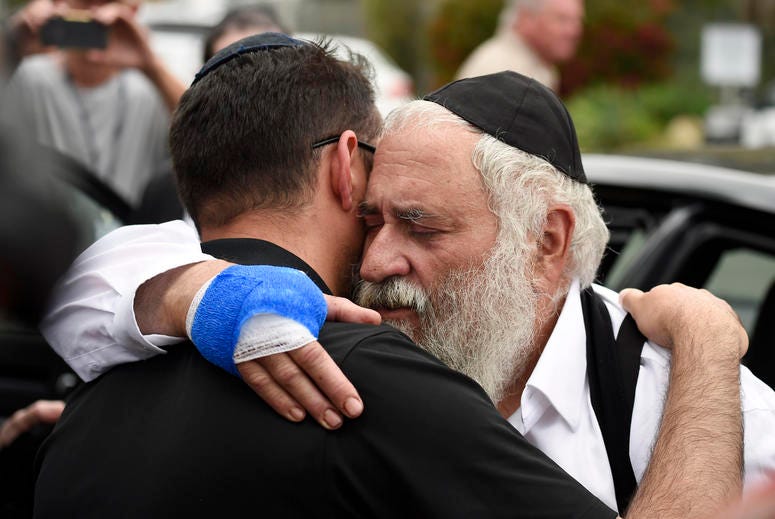 Rabbi Yisroel Goldstein, right, is hugged as he leaves a news conference at the Chabad of Poway synagogue, Sunday, April 28, 2019, in Poway, Calif. Poway, California synagogue shooting