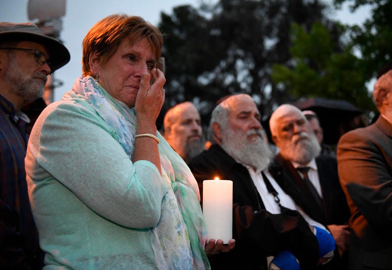 A woman cries during a candlelight vigil held for victims of the Chabad of Poway synagogue shooting, Sunday, April 28, 2019, in Poway, Calif. Poway, California synagogue shooting