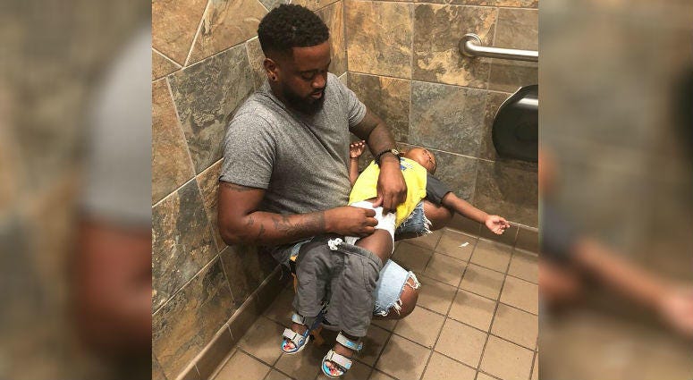 Donte Palmer changing his 1-year-old son.
