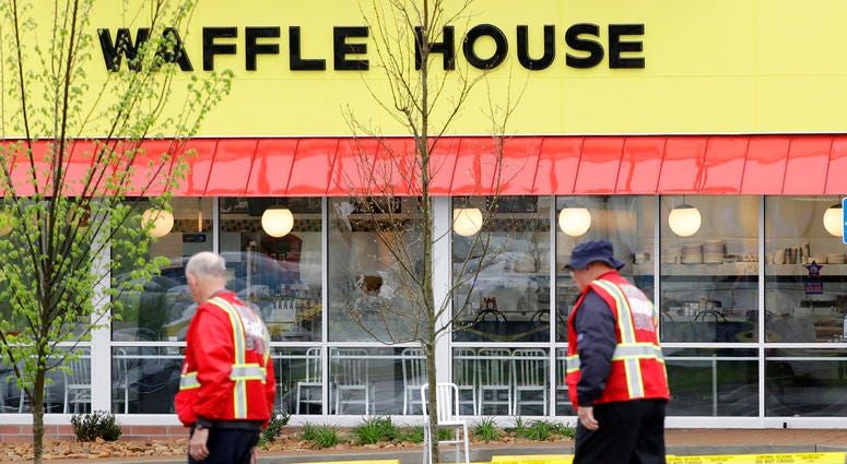 A police car sits in front of a Waffle House restaurant. A police car sits in front of a Waffle House restaurant.