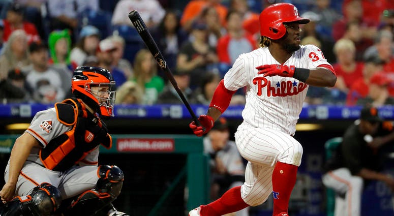 Philadelphia Phillies' Odubel Herrera, right, follows through after hitting a run-scoring single off San Francisco Giants starting pitcher Derek Holland as catcher Buster Posey, left, looks on during the third inning of a baseball game. Philadelphia Phillies' Odubel Herrera, right, follows through after hitting a run-scoring single off San Francisco Giants starting pitcher Derek Holland as catcher Buster Posey, left, looks on during the third inning of a baseball game.